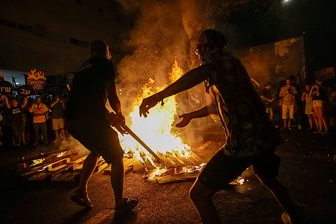 Israel-Hamas war: Demonstrators light a bonfire during a protest demanding a cease-fire deal in Tel Aviv